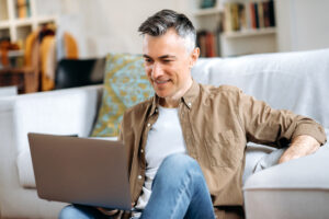Homme remplissant une demande de prêt rapide en ligne depuis son ordinateur portable à la maison.
